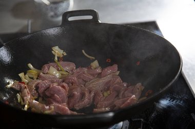 Kalfsvleesreepjes toevoegen als de olie heet is.