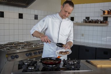 Kalfsvlees uit de pan halen.